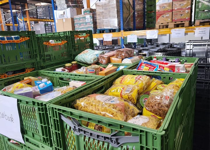 Gevulde kratten met pasta, brood en houdbare producten in een magazijn van de voedselbank Groningen.